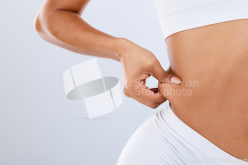 Image of Fat, lose weight and woman touching stomach in studio with liposuction mockup, space or background. Skin, cellulite and hands of feeling waist, body and diet for abdomen, obesity health or tummy tuck