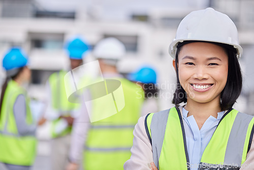 Image of Engineering, leadership and portrait of a woman construction worker on an outdoor site. Confidence, happy and Asian female industry manager or foreman standing with crossed arms on a building plot.