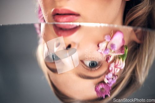 Image of Beauty, mirror face and model with flower product, sustainable agriculture and natural skincare reflection. Facial makeup, nature plant cosmetics and eco friendly woman isolated on studio background