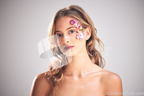 Image of Flowers, beauty and portrait of woman for cosmetic wellness, skincare and natural makeup. Spring, art and girl with petal on face for spa aesthetic, luxury facial and cosmetology on studio background