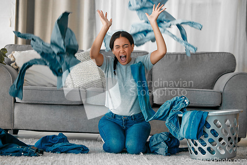 Image of Laundry, angry and woman with clothes in air frustrated from cleaning, housekeeping and housework. Burnout, washing basket and upset, stressed and shouting female maid in living room throw clothing