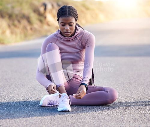 Image of Fitness, road and black woman tie shoes on street to get ready for running, exercise or workout. Sports athlete, training and female runner tying sneakers to start exercising, cardio or jog outdoors.