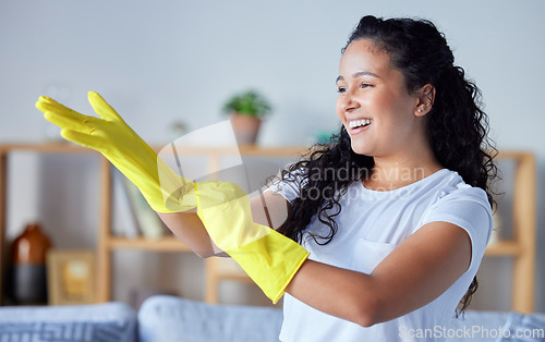 Image of Cleaning, gloves and hygiene with a black woman cleaner in her home for housekeeping or chores. Hands, bacteria and health with a happy young female in a house working as a domestic housekeeper