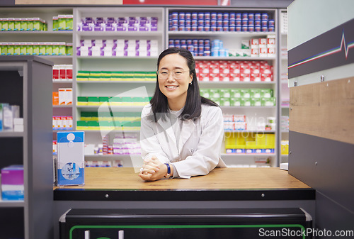 Image of Pharmacy, smile and portrait of asian woman at counter in drugstore, customer service and medical advice in Japan. Prescription drugs, happy pharmacist and inventory of pills and medicine at checkout