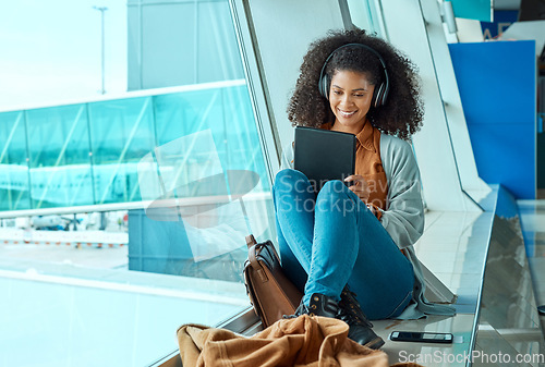 Image of Airport, travel and black woman with tablet by window waiting for flight, departure and transport. Immigration, lobby and girl with headphones on digital tech for internet, music and social media