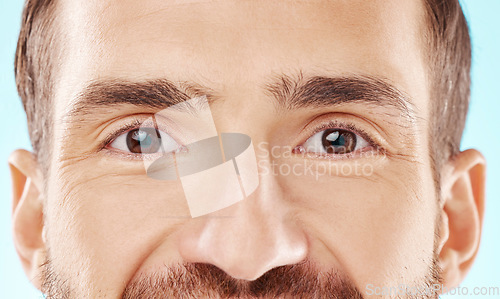 Image of Skincare, vision and zoom on man eyes, beauty and grooming portrait isolated on blue background. Eye care, health and facial wellness, good eyesight and glowing skin on happy male model in studio.