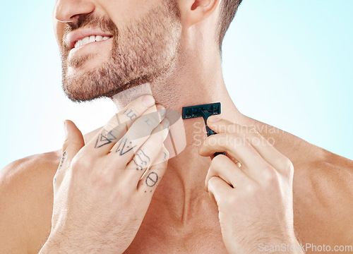 Image of Hands, shave and beard with a man grooming in studio on a blue background for skincare or hygiene. Shaving, tattoo and neck with a male in the bathroom for hair removal as part of a morning routine