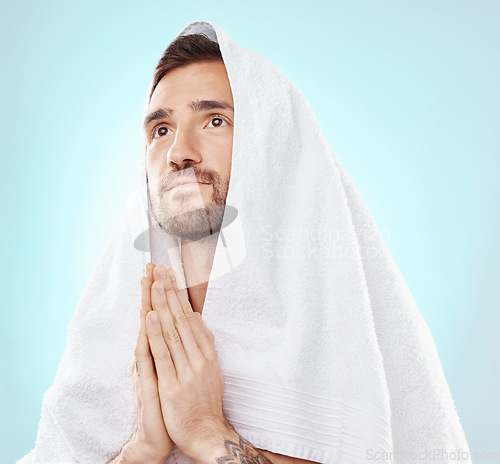 Image of Prayer, thinking and worship with man and towel for hope, spiritual and Catholic faith. Respect, religion and Holy spirit with guy and hands for believer, humble and Christianity with blue background