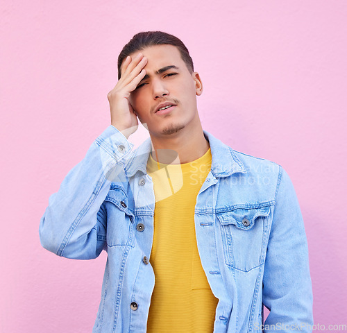 Image of Stress, portrait and man with headache in studio isolated on a pink background. Mental health, anxiety and face of depressed and sad male model with depression, pain or migraine, burnout or emoji.