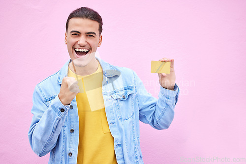 Image of Man, portrait and excited in celebration with credit card for discount, sale or bonus in ecommerce on mockup. Happy male celebrating cash, profit or salary increase against a pink studio background