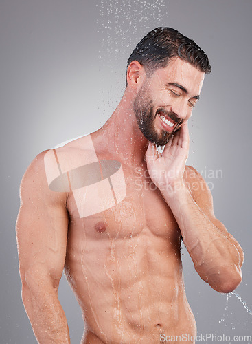 Image of Shower, water and clean man in a studio for hygiene, grooming and body care for wellness. Self care, washing and handsome male model doing a fresh morning health routine isolated by a gray background