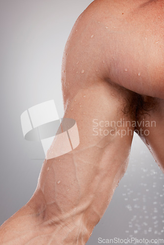 Image of Closeup, body and arm with water, veins and fitness with healthy lifestyle on grey studio background. Zoom, male athlete flexing and bodybuilder wet, hygiene and cleaning for wellness and training