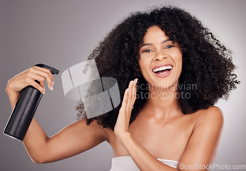 Image of Portrait of black woman spray on hair for wellness, growth and natural shine on gray background. Beauty, salon and happy face of girl smile with hairspray, cosmetic products and keratin treatment