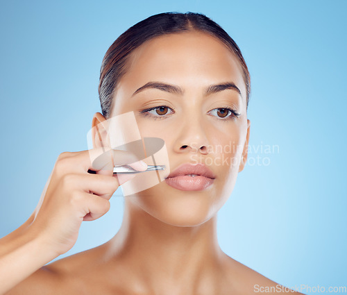 Image of Tweezer, lip and hair removal with woman in studio for beauty, grooming and hygiene on blue background. Facial, moustache and product or tool for girl model with mouth, hairs and cleaning isolated