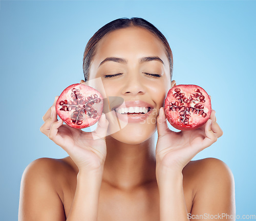 Image of Pomegranate beauty, woman and skincare for face, clean wellness and studio background. Happy model, smile and healthy fruits for natural cosmetics, detox nutrition and facial aesthetic of dermatology