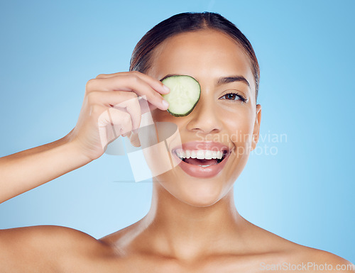 Image of Cucumber, woman and portrait of smile for skincare, face beauty and wellness diet on studio background. Happy model, eyes and green fruits cosmetics for detox, facial nutrition and aesthetic benefits