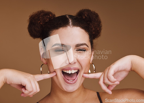 Image of Woman, portrait or fun cheek fingers on isolated brown background for self love, goofy or silly facial expression. Smile, happy or beauty model with fashion hairstyle makeup cosmetics or emoji face