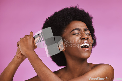 Image of Stress, hairstyle and afro brushing on beauty studio background in grooming, texture anxiety or crisis. Black woman, comb and natural hair with damage, split ends or frizzy knots on isolated skincare