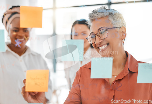 Image of Planning, meeting or happy CEO writing a marketing strategy, advertising plan or branding ideas. Sticky notes, senior woman or manager working on a global startup project with creative employees