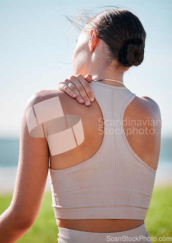 Image of Massage, shoulder pain and fitness with woman at beach for yoga, workout and exercise training. Burnout, injury and physical therapy with girl in city park for training, sport and pilates goals