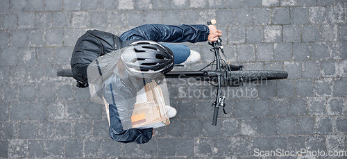 Image of Top view, bicycle and delivery man with box in city for package, logistics and shipping. Courier, eco friendly transport and male bike driver with cargo, stock or goods for ecommerce on road in town.