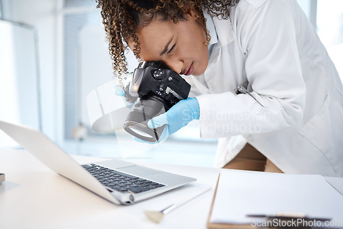 Image of Black woman, forensic investigation and camera for laptop, it and cyber crime evidence on lab desk. Young technician, photography or computer for digital analysis of online criminal for cybersecurity