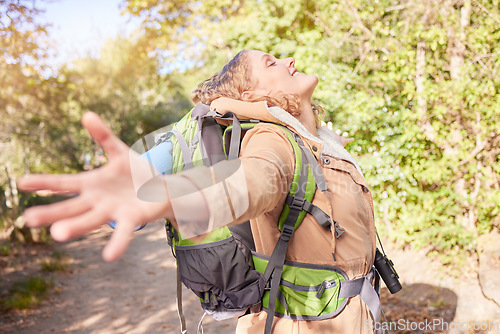 Image of Woman hiking, freedom and open hands in nature with happiness, wellness and outdoor adventure in summer. Happy hiker girl, free and smile sunshine in woods, forrest and walk with backpack on holiday