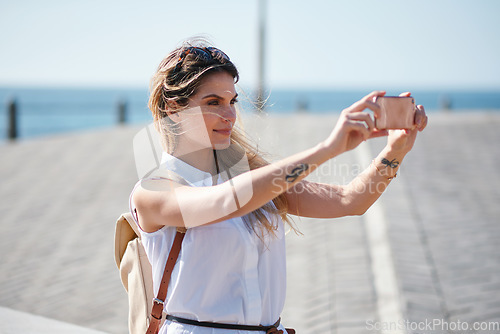 Image of Travel, selfie and woman relax at beach, calm and posing for photo on blurred background. Sightseeing, girl and social media influencer with update post for blog, profile picture or live streaming