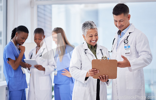 Image of Doctors team, man and woman with checklist, smile and happy for results, progress or feedback in clinic. Doctor, nurse and diversity with paperwork, tablet and happiness for team building in hospital