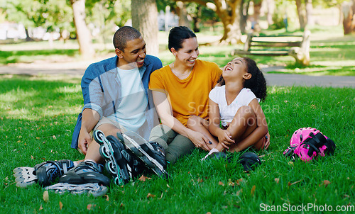 Image of African family, girl and park with rollerblades, interracial bonding and laugh for comic joke, happy or holiday. Black man, woman and child with happiness, care and diversity on grass for vacation