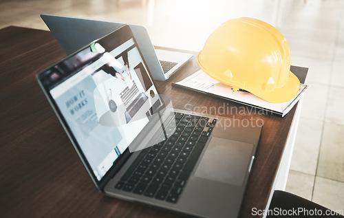 Image of Laptop, hardhat and desk in an industry office for engineering architecture project planning. Industrial, construction and computer or technology for research with a safety helmet in the workplace.
