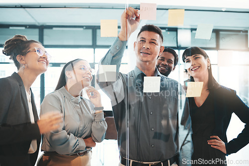 Image of Business people, writing and planning schedule, brainstorming or strategy on glass wall at office. Group of employee workers in team project plan, tasks and write for post it or sticky note together