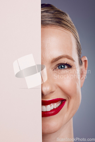 Image of Half, mockup and portrait of a woman with makeup isolated on a grey studio background. Space, cosmetics and face of a young, smiling and confident happy model with cosmetic glamour on a backdrop