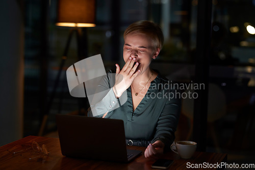Image of Tired, late and woman working on a laptop, yawning and feeling burnout in a dark office. Sleepy, overworked and employee with fatigue doing overtime for a project deadline at night on a computer