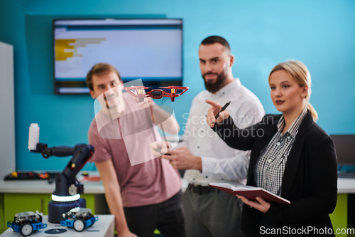 Image of A group of students working together in a laboratory, dedicated to exploring the aerodynamic capabilities of a drone