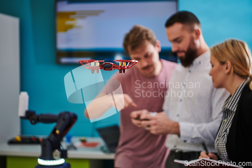Image of A group of students working together in a laboratory, dedicated to exploring the aerodynamic capabilities of a drone