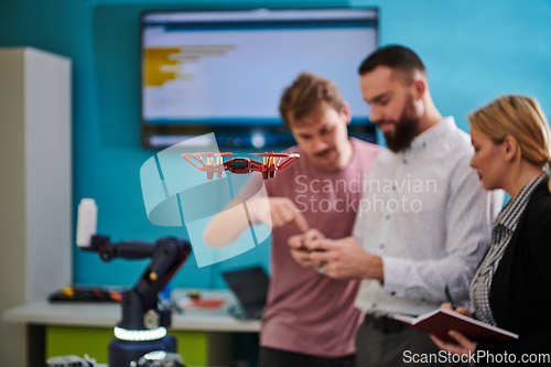 Image of A group of students working together in a laboratory, dedicated to exploring the aerodynamic capabilities of a drone