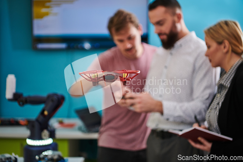 Image of A group of students working together in a laboratory, dedicated to exploring the aerodynamic capabilities of a drone