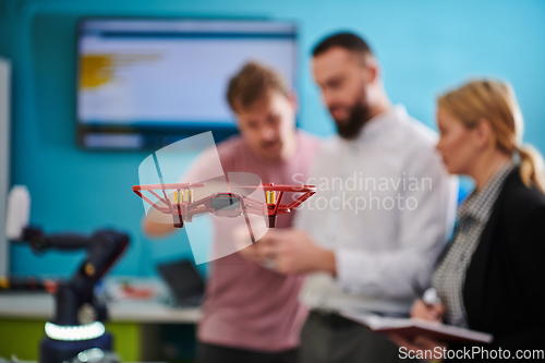 Image of A group of students working together in a laboratory, dedicated to exploring the aerodynamic capabilities of a drone