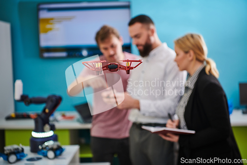 Image of A group of students working together in a laboratory, dedicated to exploring the aerodynamic capabilities of a drone