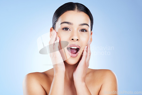 Image of Skincare, shock and portrait of a woman in a studio with a beauty, natural and face routine. Surprise, health and female model from Brazil with a shocking facial treatment isolated by blue background