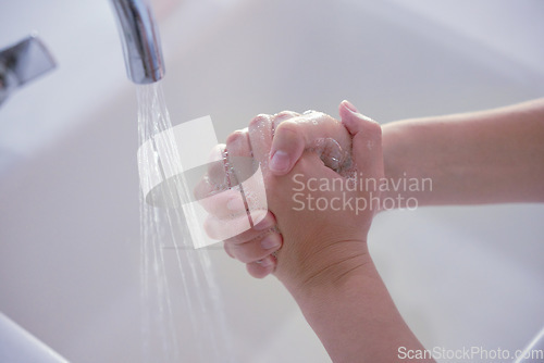 Image of Hygiene, above and person washing hands with water for health, disinfection and virus protection. Soap, healthy and liquid from a basin to wash, clean and prevent disease on fingers of a human