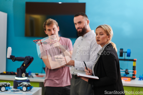 Image of A group of students working together in a laboratory, dedicated to exploring the aerodynamic capabilities of a drone