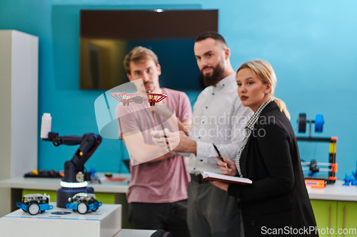 Image of A group of students working together in a laboratory, dedicated to exploring the aerodynamic capabilities of a drone