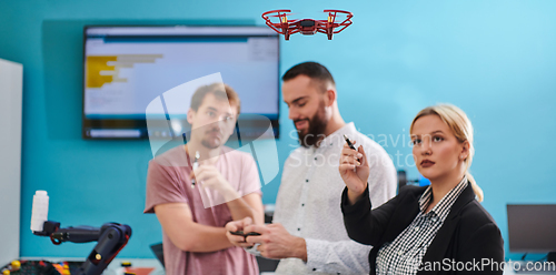 Image of A group of students working together in a laboratory, dedicated to exploring the aerodynamic capabilities of a drone