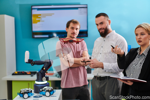 Image of A group of students working together in a laboratory, dedicated to exploring the aerodynamic capabilities of a drone