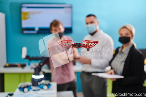 Image of A group of students working together in a laboratory, dedicated to exploring the aerodynamic capabilities of a drone