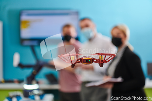 Image of A group of students working together in a laboratory, dedicated to exploring the aerodynamic capabilities of a drone