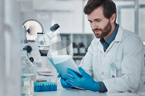 Image of Science, medical research and man with tablet in laboratory checking results, internet or email online. Healthcare, medicine and innovation in vaccine manufacturing, scientist reading journal website
