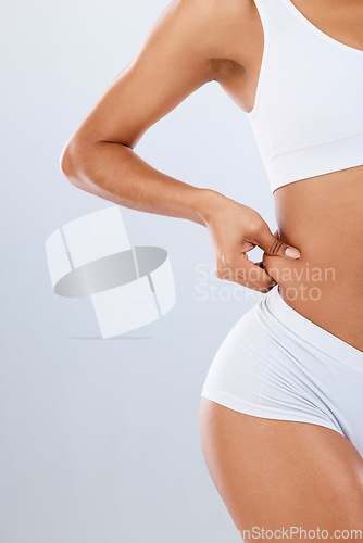 Image of Fat, weightloss and woman pinch stomach in studio with liposuction mockup, space or background. Skin, cellulite and hands of feeling waist, body and diet for abdomen, obesity health or tummy tuck